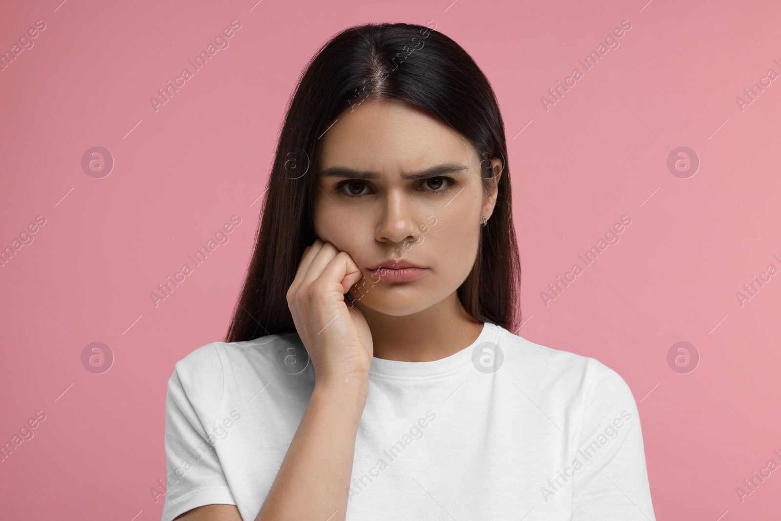 Photo of Portrait of resentful woman on pink background