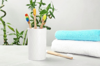 Bamboo toothbrushes and holder on table indoors. Dental care