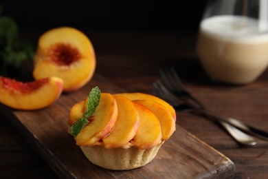 Photo of Delicious peach dessert on wooden table, closeup