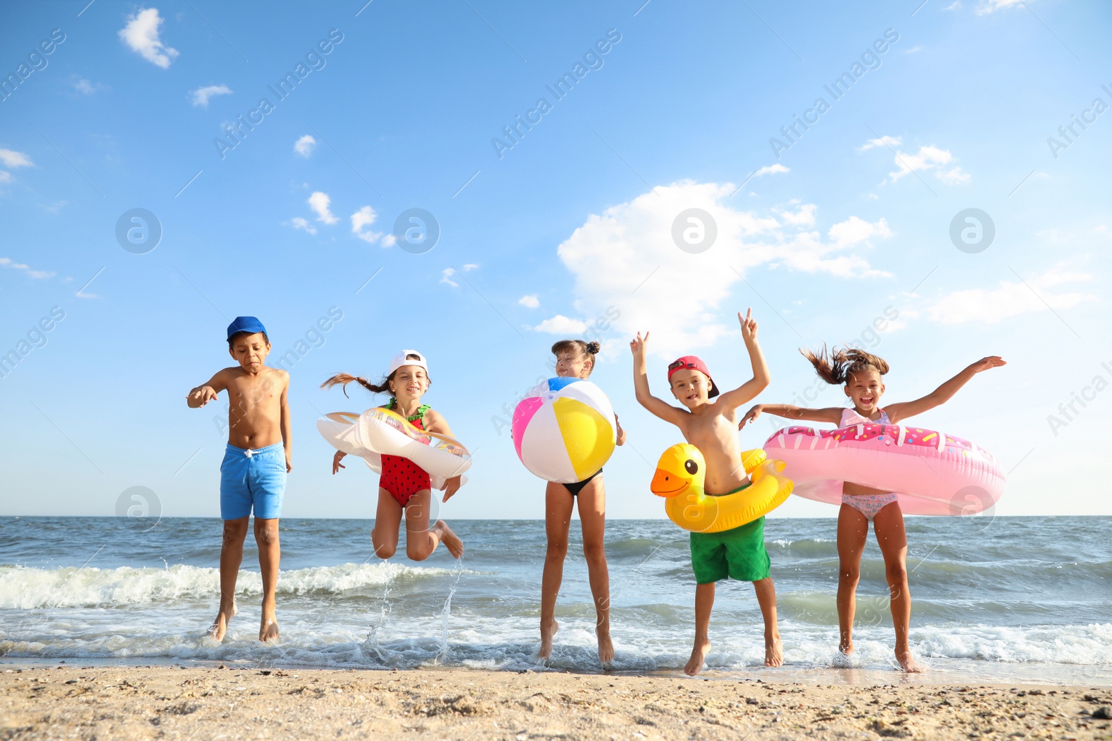 Photo of Cute children enjoying sunny day at beach. Summer camp