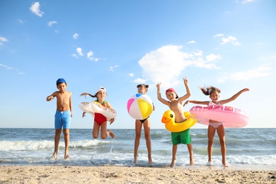 Photo of Cute children enjoying sunny day at beach. Summer camp