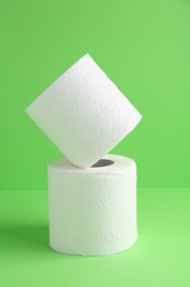 Photo of Soft toilet paper rolls on green background, closeup