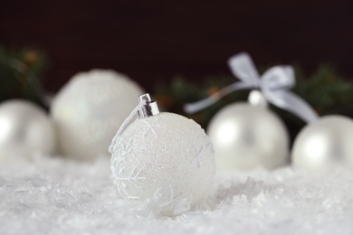 Photo of Beautiful Christmas ball on snow against blurred background
