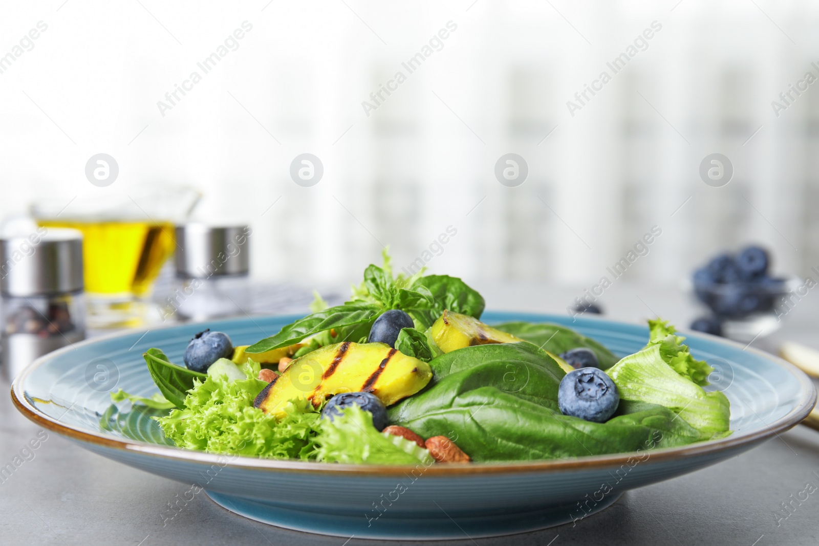 Photo of Delicious avocado salad with blueberries on grey table