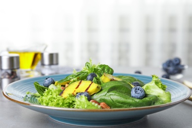 Delicious avocado salad with blueberries on grey table