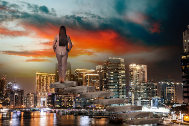 Image of Woman standing on top of stairs and looking at cityscape. Way to success