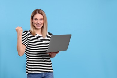 Emotional woman with laptop on light blue background. Space for text