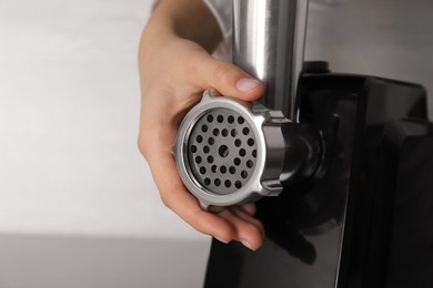 Photo of Woman assembling electric meat grinder, closeup view