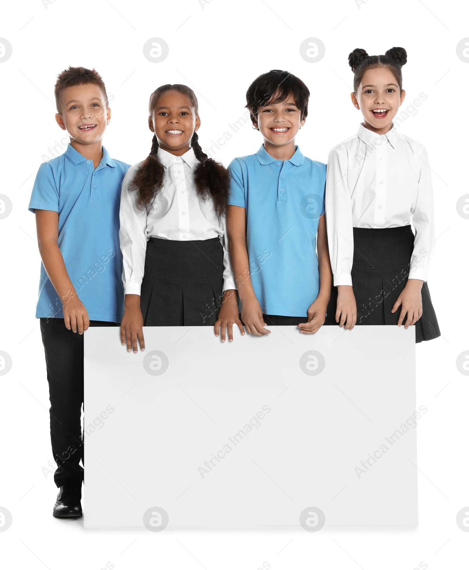 Photo of Happy children in school uniform with blank board on white background