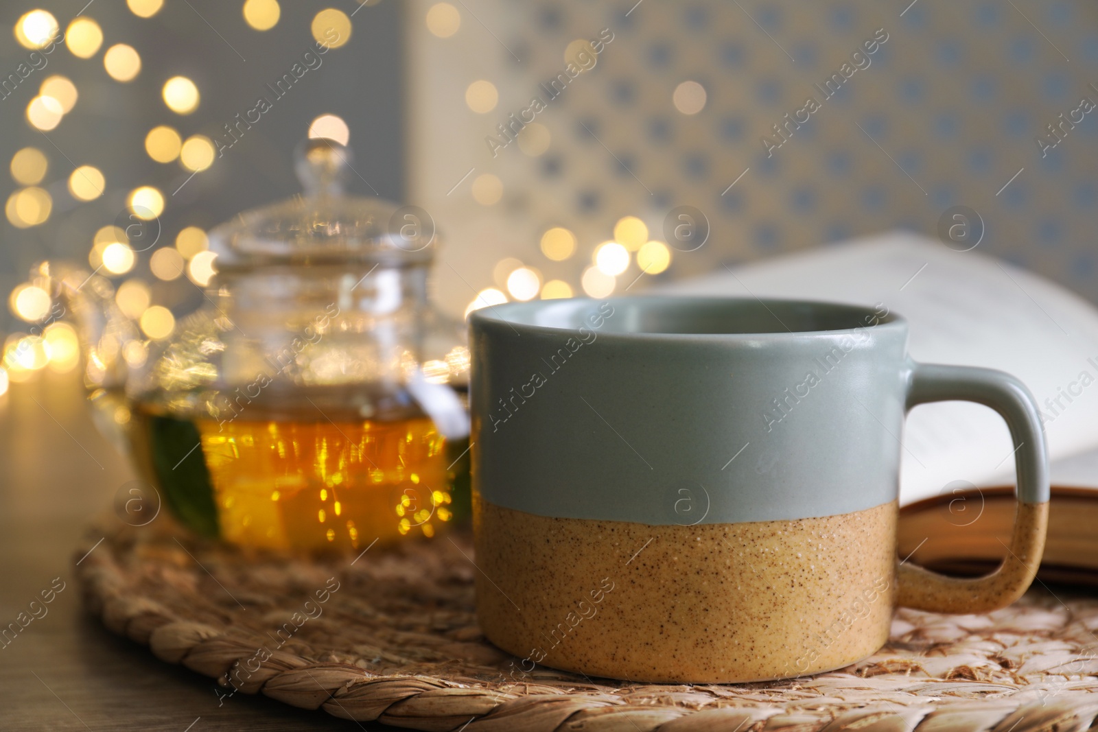 Photo of Cup of drink on wooden table against blurred lights, closeup. Space for text