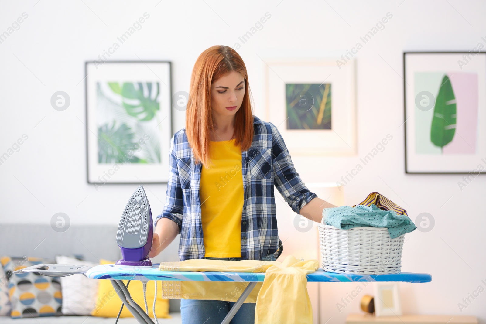 Photo of Tired housewife ironing clothes at home