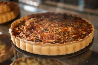 Photo of Delicious quiche on counter in bakery shop, closeup