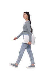 Photo of Young woman with laptop walking on white background