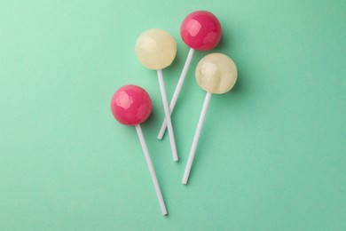 Tasty lollipops on turquoise background, flat lay