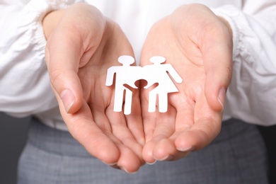 Photo of Woman holding cutout paper family, closeup. Life insurance concept