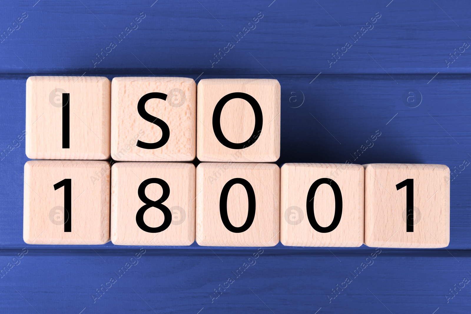 Photo of International Organization for Standardization. Cubes with abbreviation ISO and number 18001 on blue wooden table, flat lay