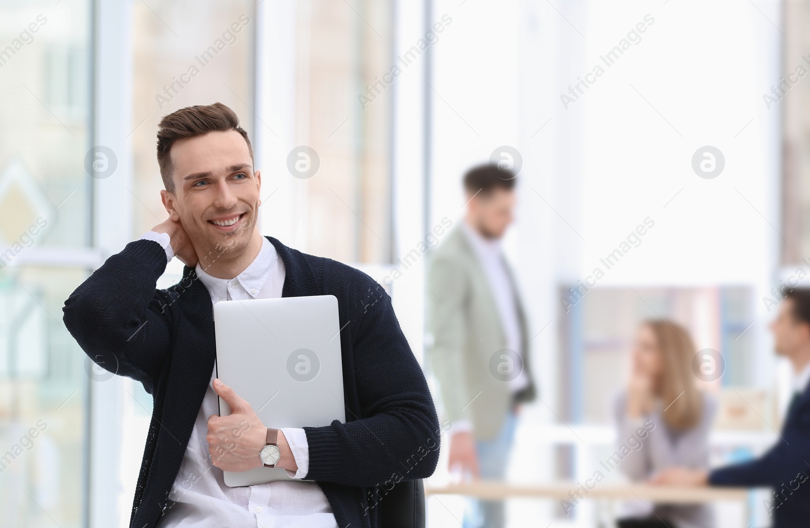 Photo of Portrait of handsome young businessman with laptop in office