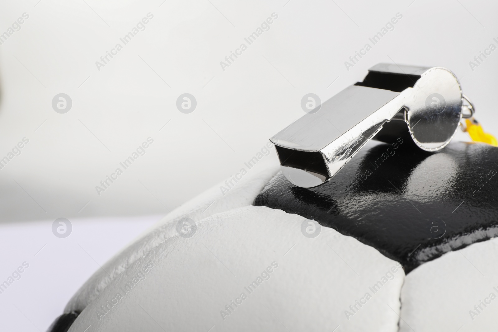 Photo of Football referee equipment. Soccer ball and whistle on white background