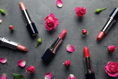 Flat lay composition with lipsticks and roses on grey background