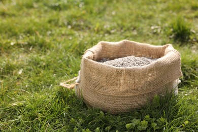 Photo of Fertilizer in bag on green grass outdoors