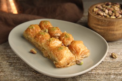 Photo of Delicious baklava with pistachios on wooden table