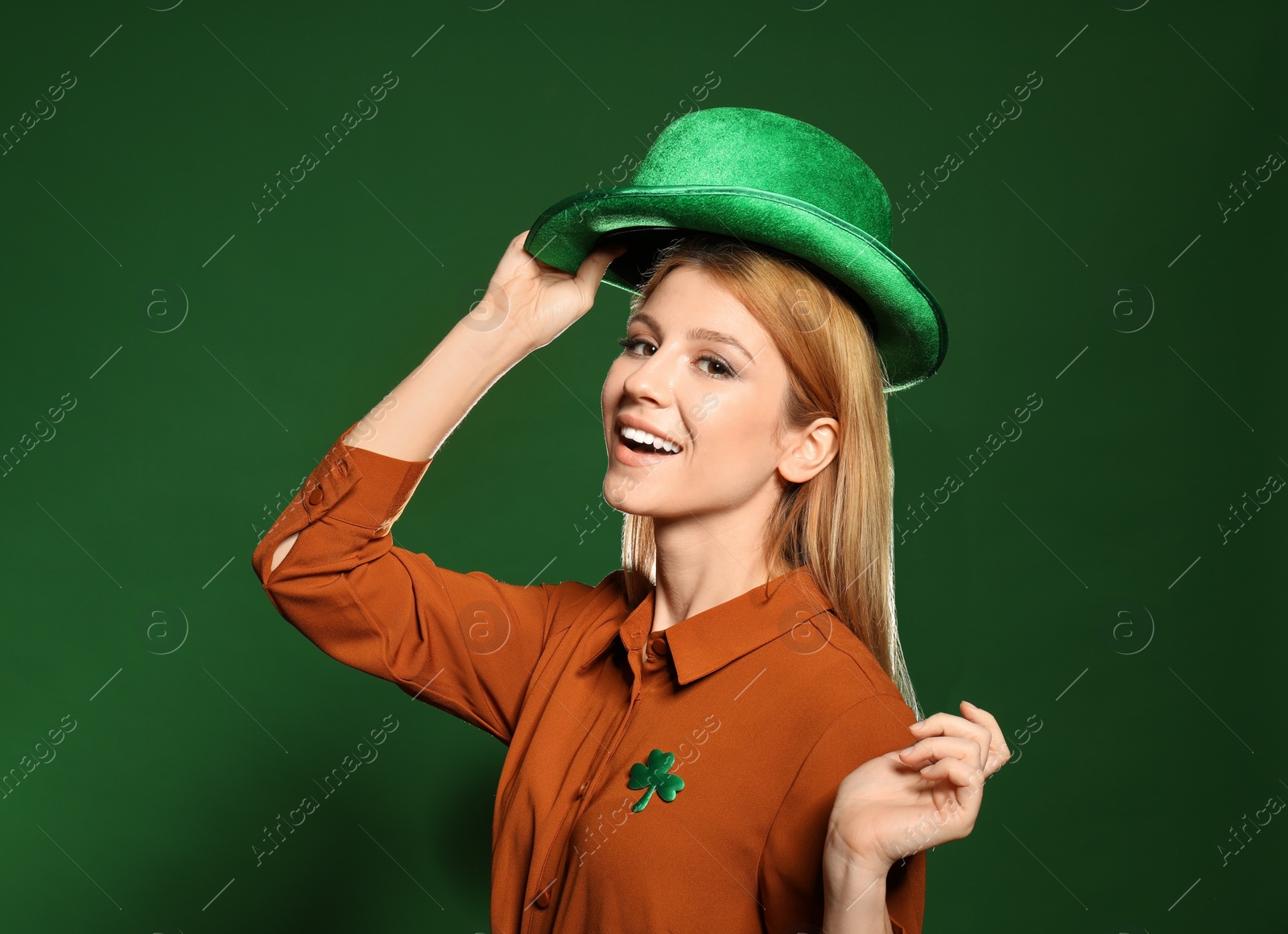 Photo of Young woman with green hat on color background. St. Patrick's Day celebration