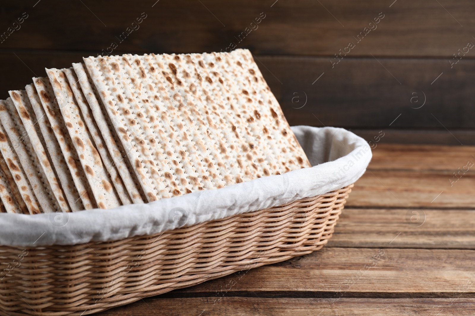 Photo of Traditional matzos in basket on wooden table