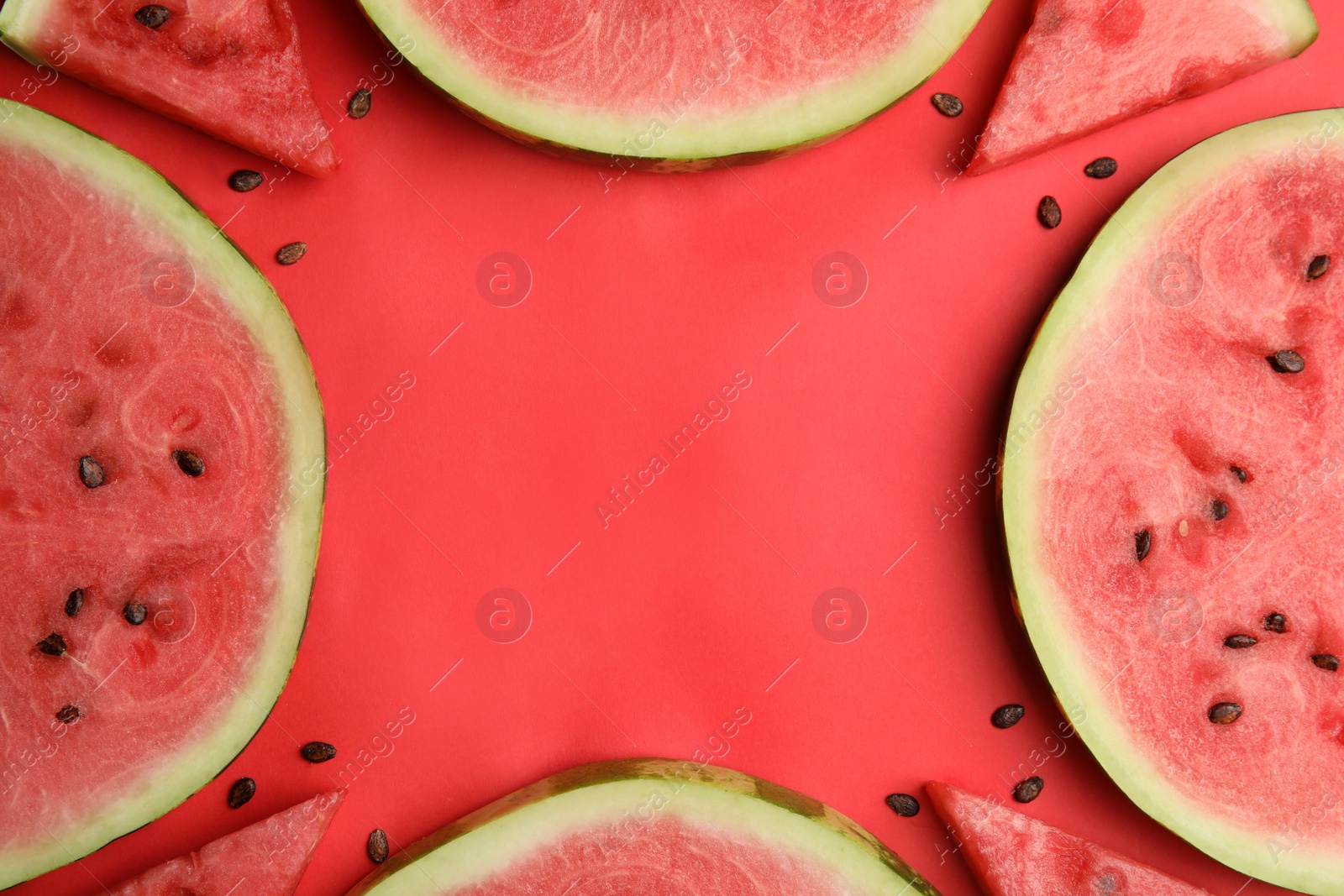 Photo of Frame made with slices of ripe watermelon on red background, flat lay. Space for text