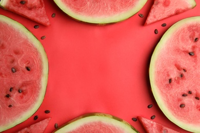 Frame made with slices of ripe watermelon on red background, flat lay. Space for text