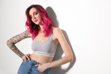 Photo of Beautiful woman with tattoos on body against white background. Space for text