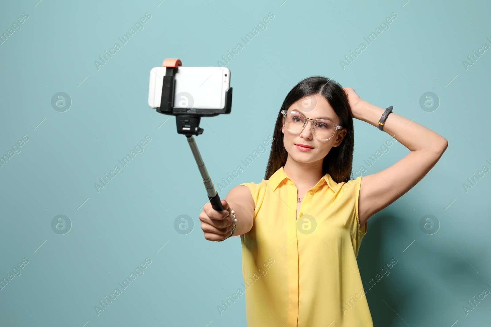 Photo of Attractive young woman taking selfie on color background