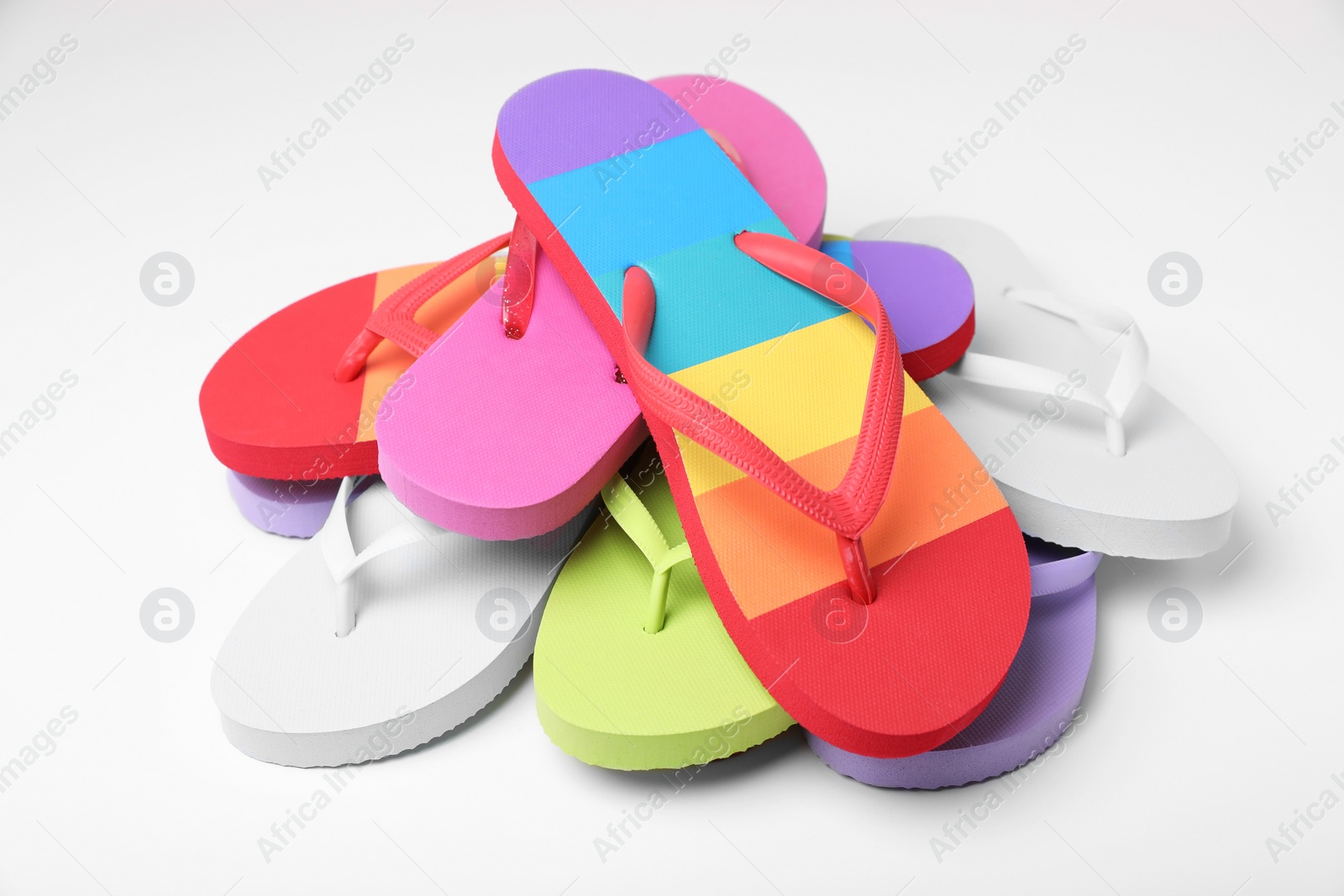 Photo of Many different flip flops on white background