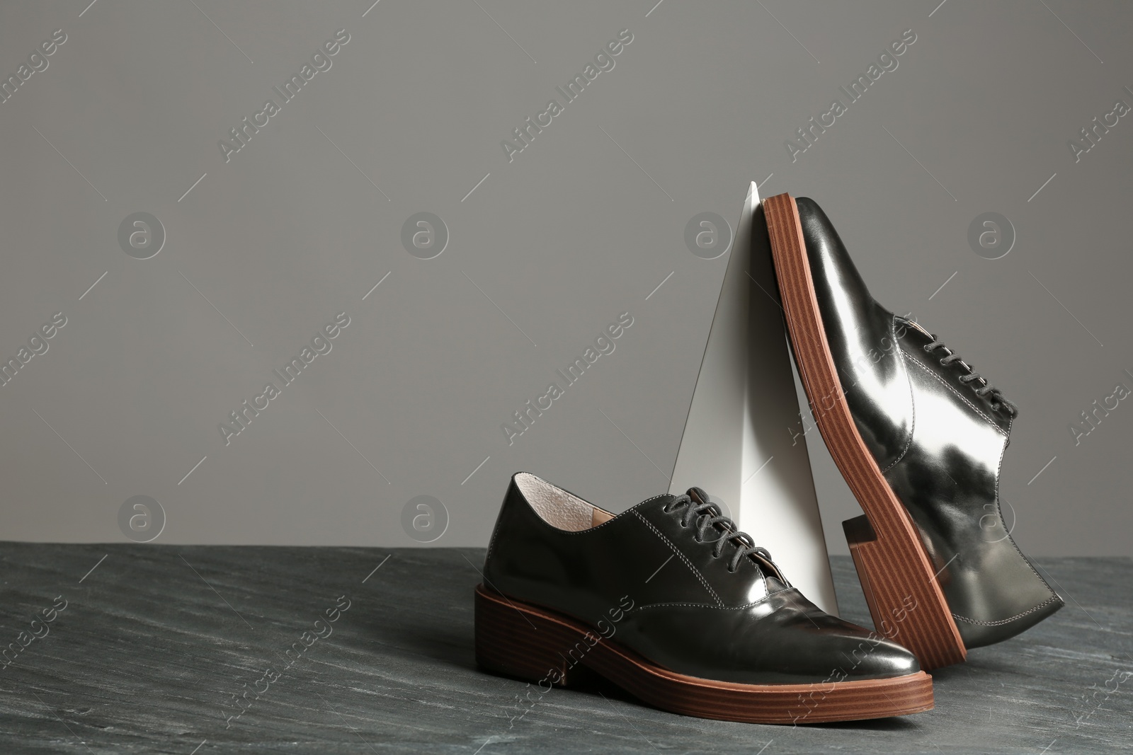 Photo of Composition with elegant shoes on table against grey background. Space for text