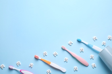 Photo of Toothbrushes on light blue background, flat lay. Space for text