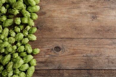 Photo of Fresh green hops on wooden table, top view. Space for text