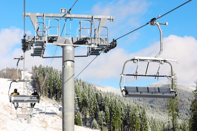 Photo of Chairlift at mountain ski resort. Winter vacation