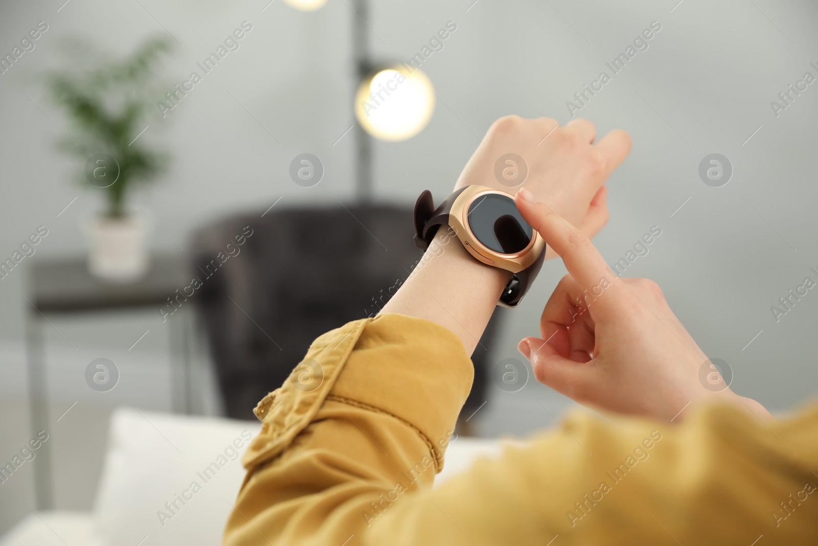 Photo of Woman checking smart watch at home, closeup