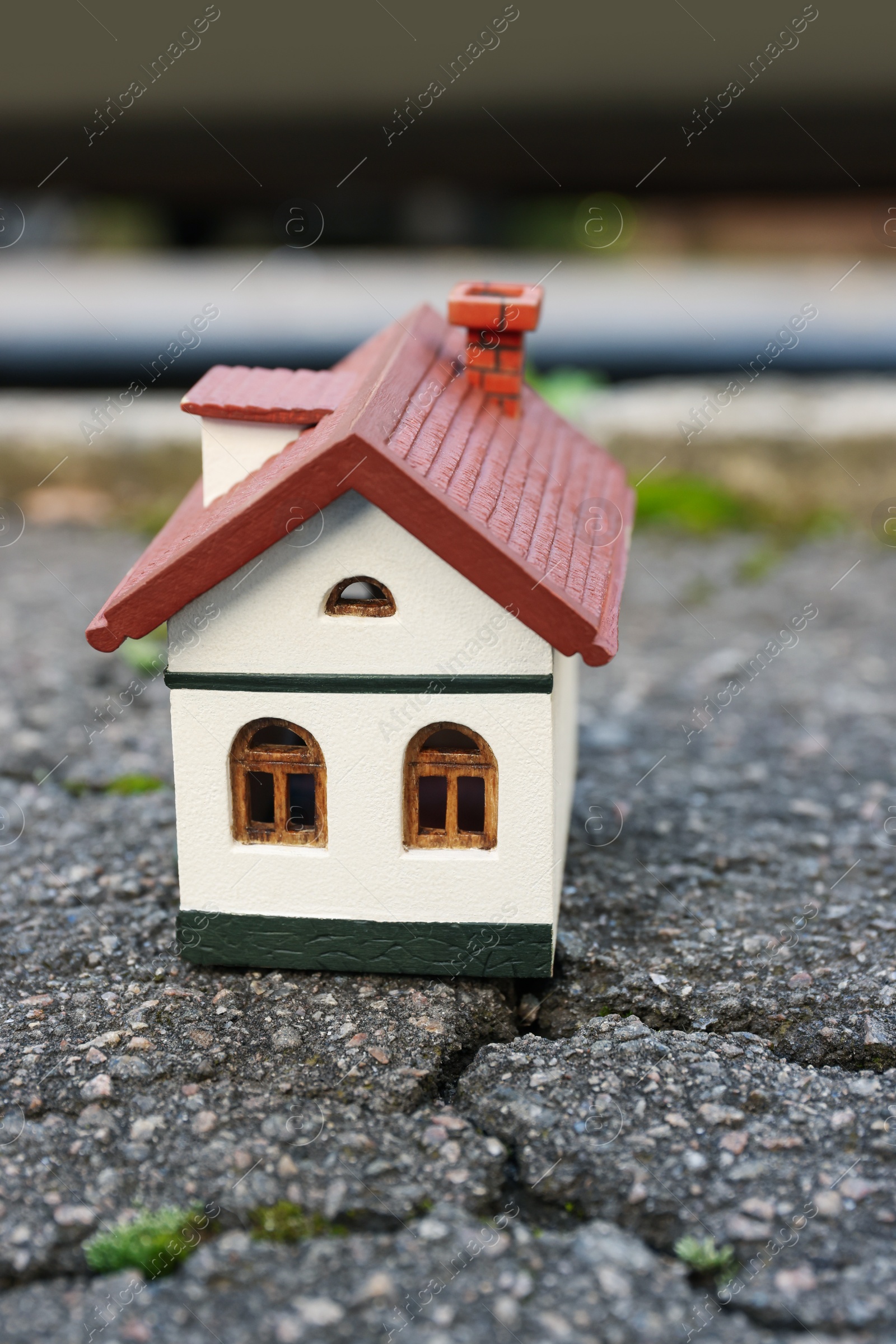 Photo of House model on cracked asphalt. Earthquake disaster