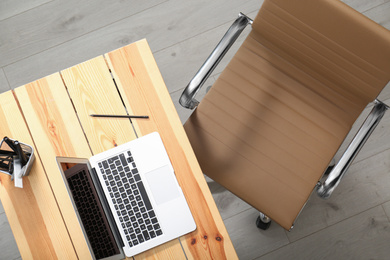 Comfortable workplace with office chair and wooden table, top view