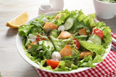 Photo of Delicious salad with chicken and vegetables on wooden table, closeup