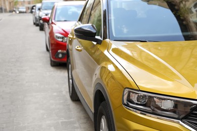 Colorful cars parked on city street, closeup