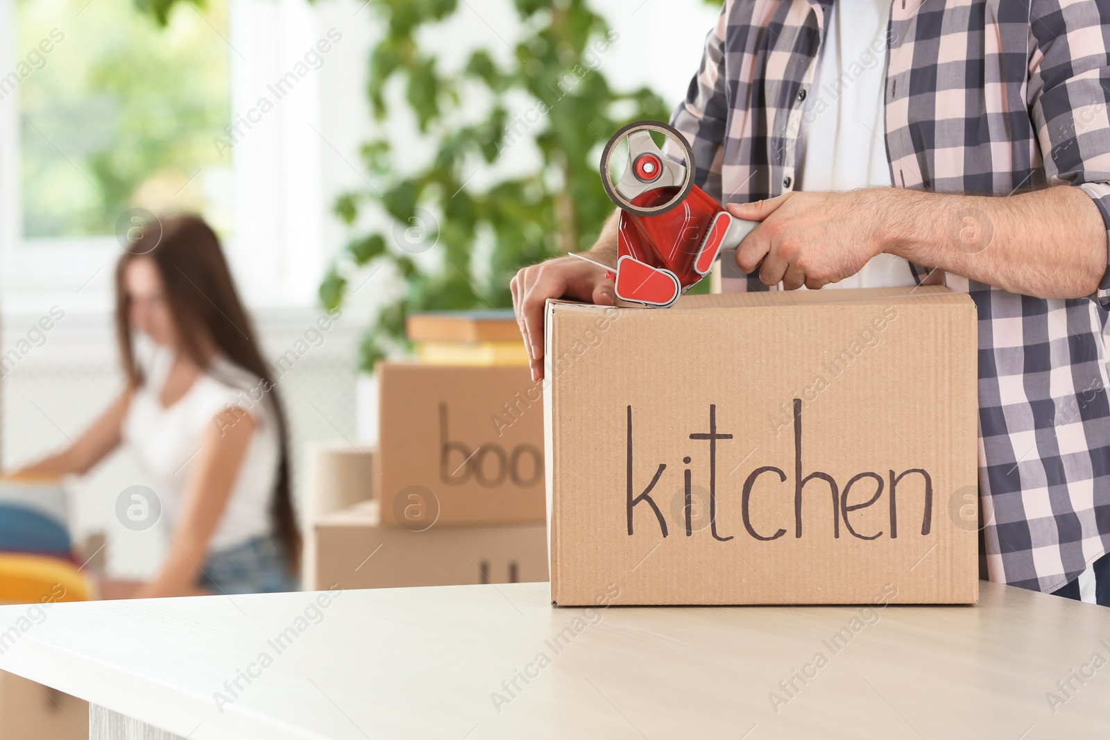 Photo of Man packing moving box indoors, closeup. Space for text