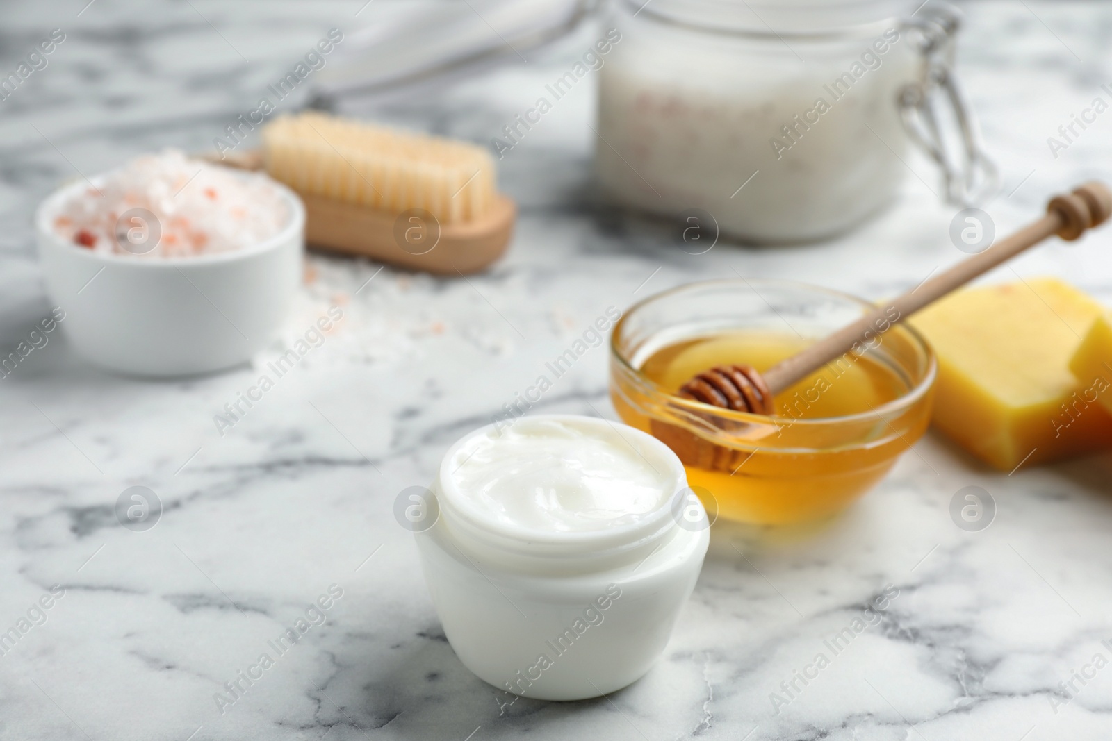 Photo of Cream with natural beeswax component on white marble table