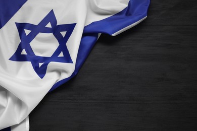 Photo of Flag of Israel on black wooden background, top view and space for text. National symbol