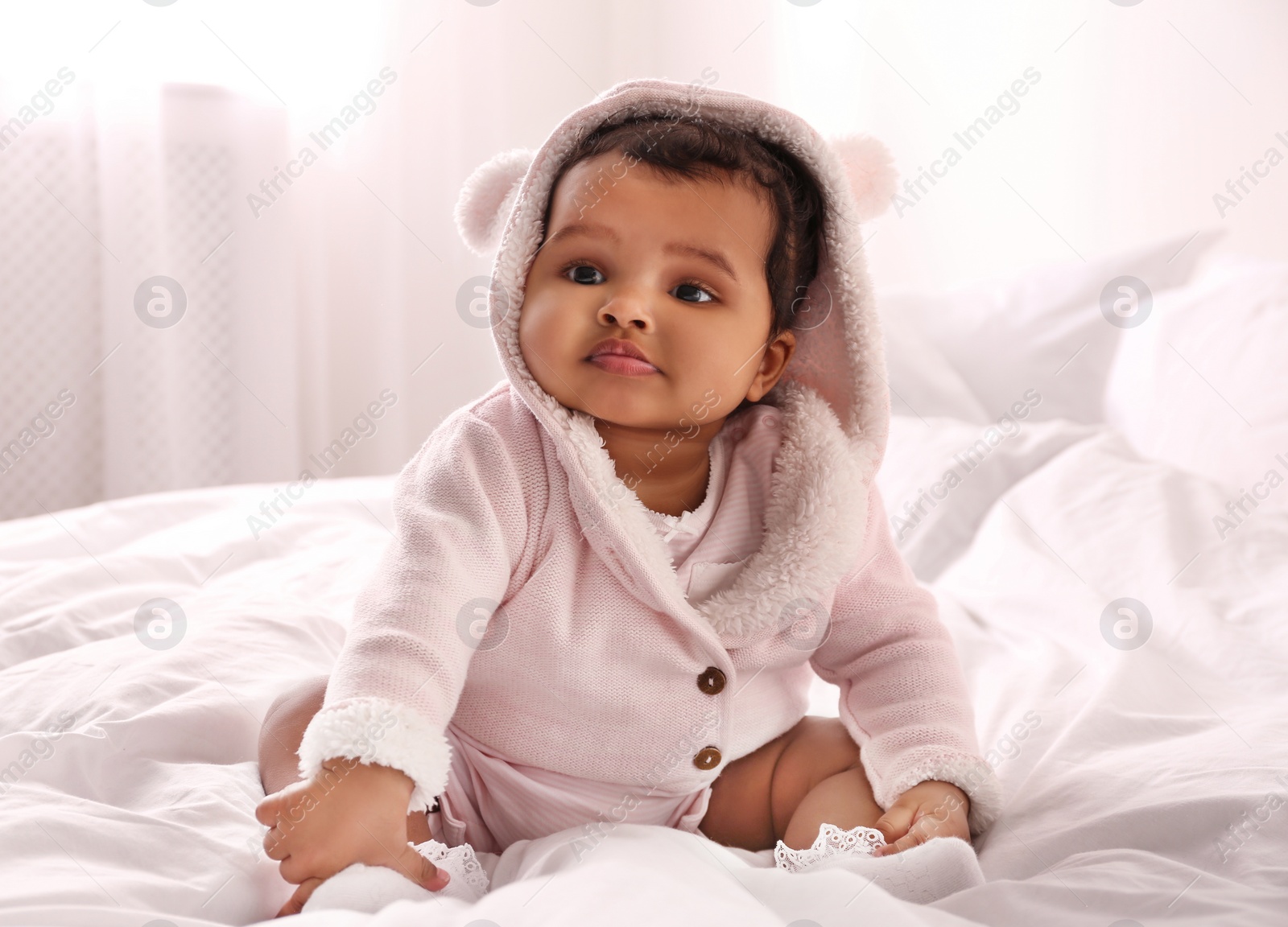 Photo of Cute African American baby on bed at home