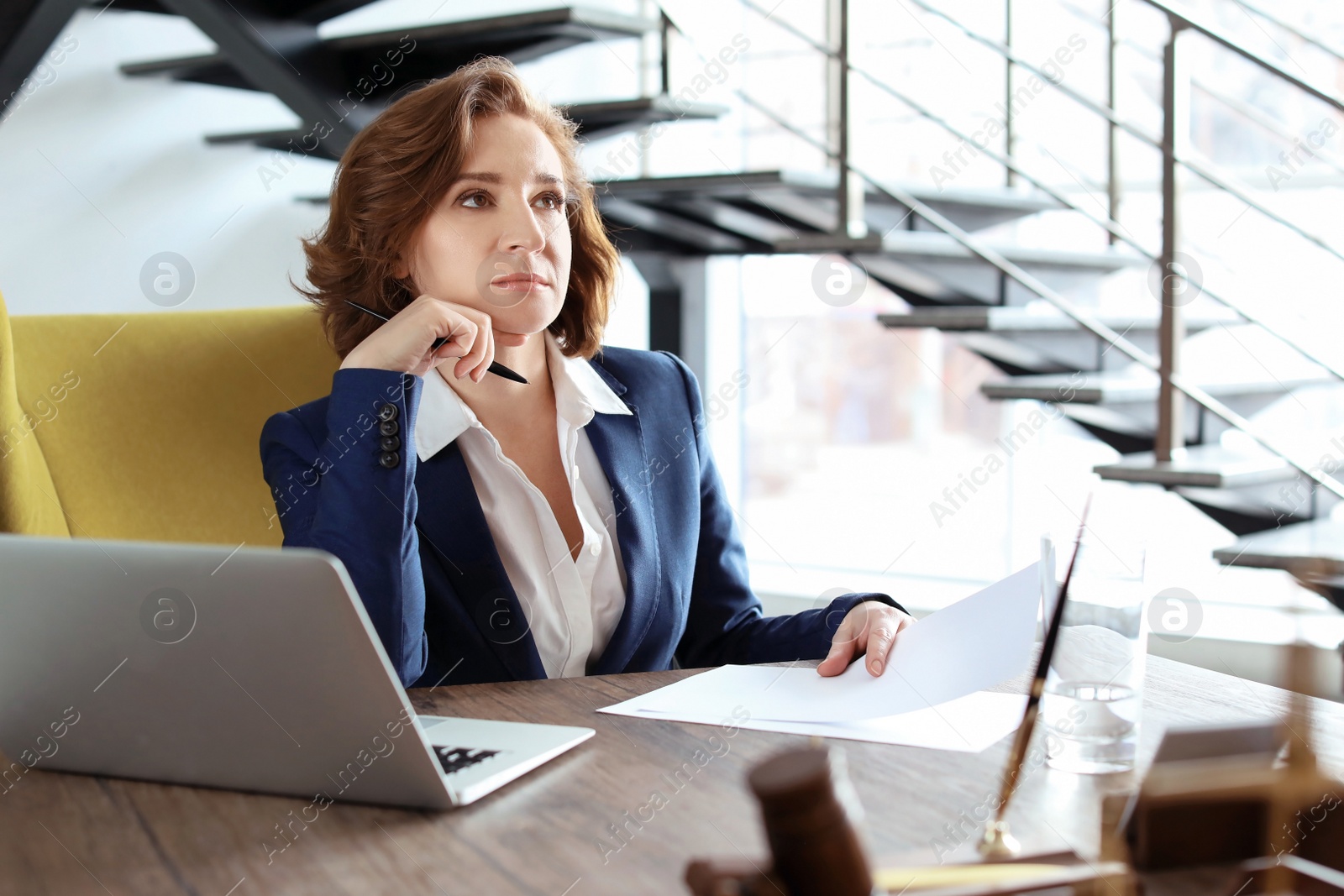 Photo of Female lawyer working at table in office