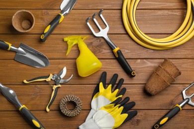 Photo of Flat lay composition with gardening tools on wooden background