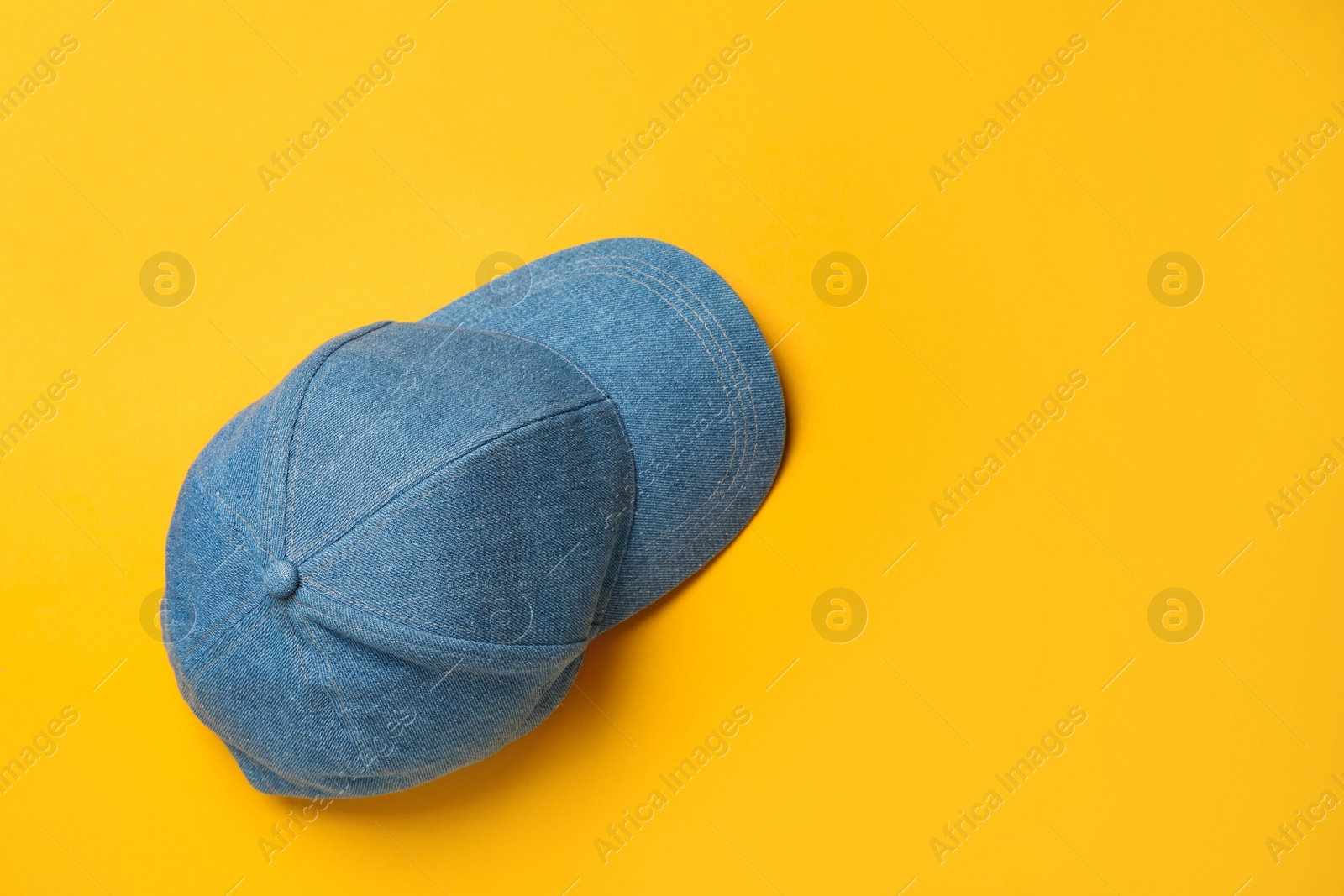 Photo of Baseball cap on orange background, top view. Space for text