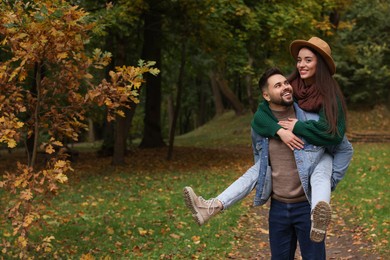 Photo of Romantic young couple spending time together in autumn park, space for text