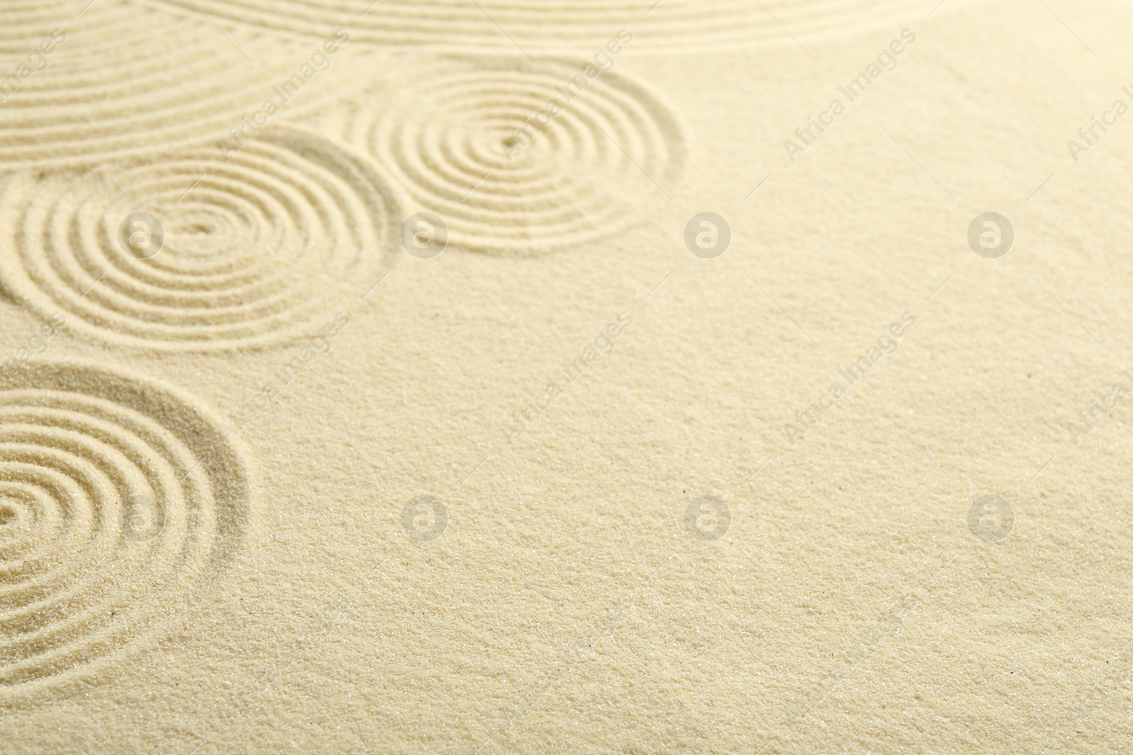 Photo of Zen rock garden. Circle patterns on beige sand